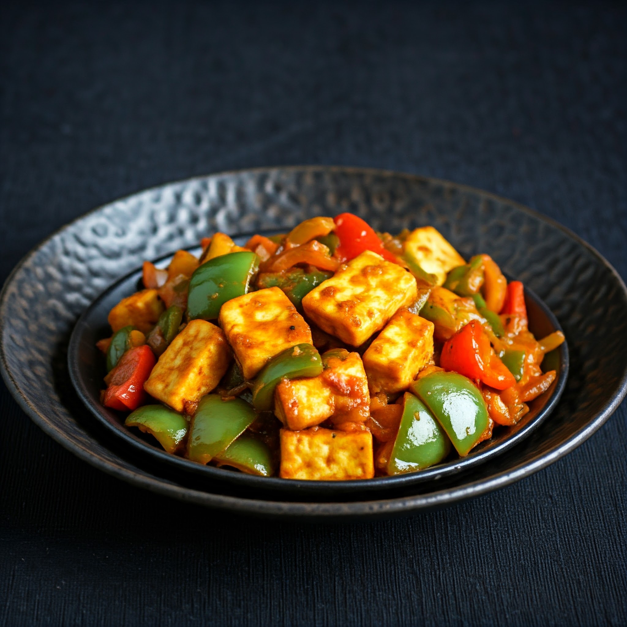 Stir-fried paneer with crispy bell peppers, served on a plate. | Planmeal