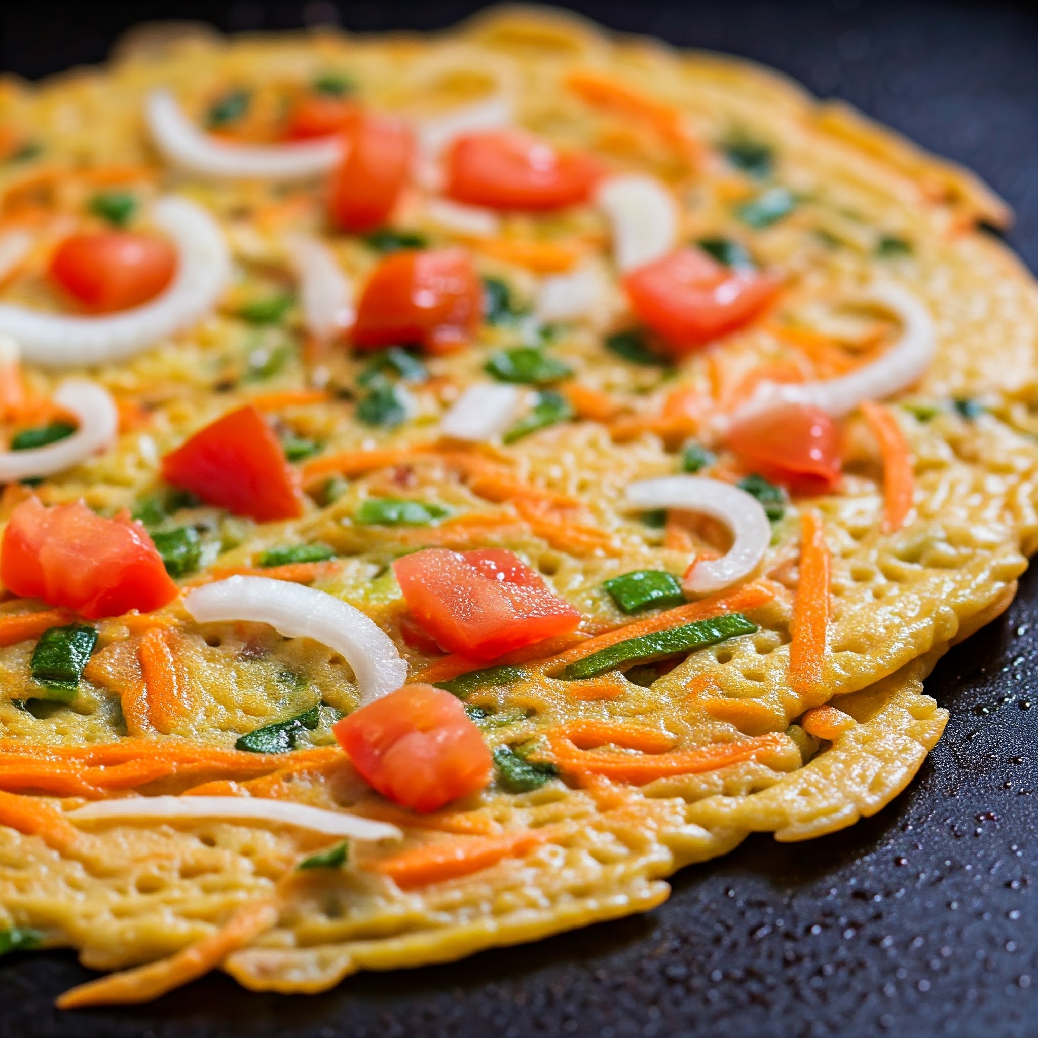 Soft and crispy savory pancake with colorful vegetable toppings, cooked to perfection. | Planmeal